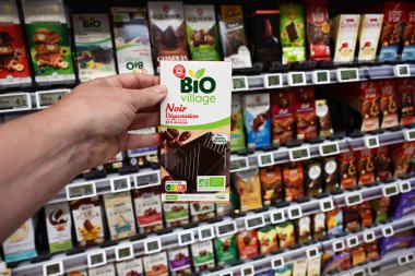 FRANCE - MAYIS 2025: Müşteri Leclerc 'in özel markası, Marque Repere, Bio Village çikolatası, E.Lerclerc Hipermarketi' ndeki çeşitli çikolatalardan% 85 'lik koyu kakao tadıyor.