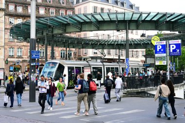 STRASBOURG, FRANCE - Mayıs 2025: Strasbourg 'daki en işlek tramvay istasyonu Homme de Fer' in yanından geçen yayalar.