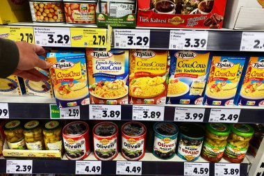 GERMANY - HAZİRAN 2024: Alışverişçi Tipiak markası Kuskus 'u bir Alman Kaufland Hipermarketinde Akdeniz yemekleri için çeşitli malzemelerle koridordan seçti.