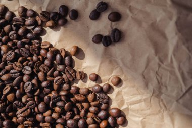 Kahverengi kağıt üzerine kahve çekirdekleri arka plan olarak kullanılabilir.