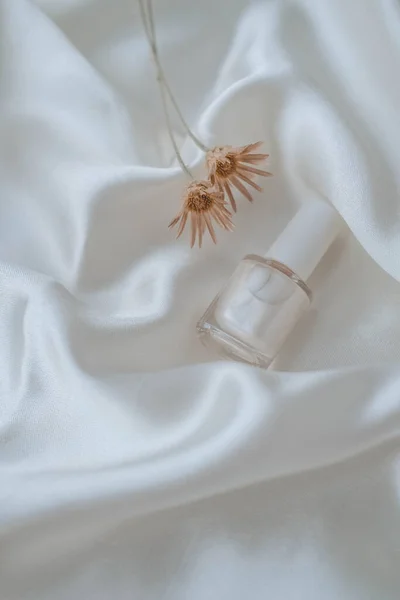 Beyaz ipek arka planda oje şişeleri, güzellik ve moda konsepti
