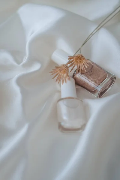 Beyaz ipek arka planda oje şişeleri, güzellik ve moda konsepti