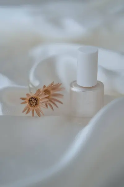 Beyaz ipek arka planda oje şişeleri, güzellik ve moda konsepti