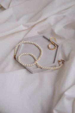 Beyaz ipek arka planda bir kutuda inci kolye. Düğün aksesuarları