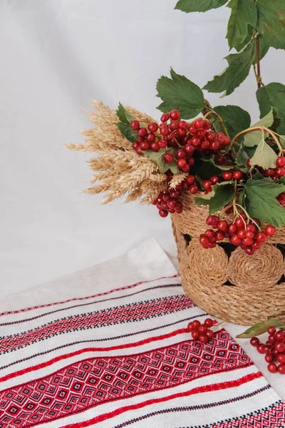 Masanın üzerinde bir sepet kırmızı viburnum meyvesi.