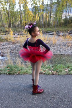 Little dancer in a pink tutu dancing outdoors clipart