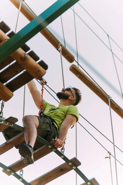 冒険公園のはしごでバランスを取るハンサムな男 — ストック写真