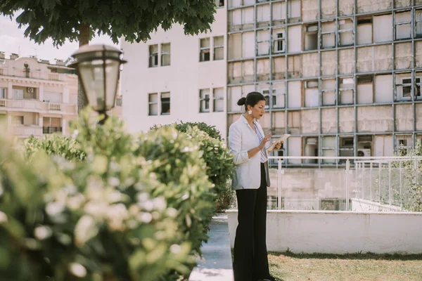 Όμορφη Επιχειρηματίας Που Κοιτάζει Τάμπλετ Της Ενώ Στέκεται Στο Πάρκο — Φωτογραφία Αρχείου