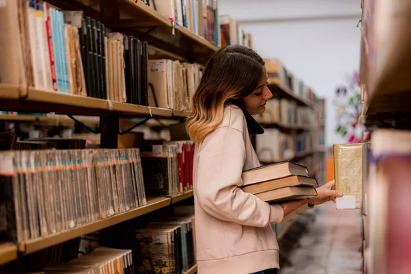 College Mädchen Telefoniert Während Sie Ein Buch Zurücklegt — Stockfoto