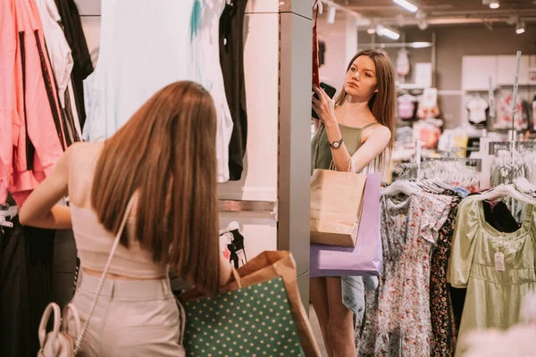 Chicas Bonitas Con Bolsas Compras Tienda Mirando Través Ropa —  Fotos de Stock