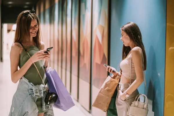 Güzel Arkadaş Alışveriş Merkezinin Koridorunda Beklerken Telefonlarını Tutuyorlar — Stok fotoğraf