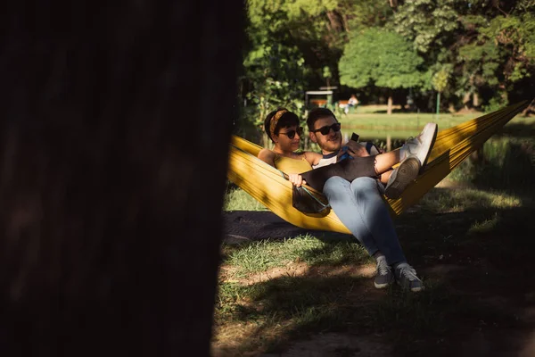 Belo Casal Sentado Rede Amarela Segurando Uma Câmera Polaroid Olhando — Fotografia de Stock