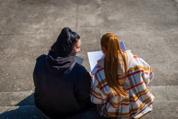 Två Glada Gymnasietjejer Sitter Trappan Och Skriver Sina Läxor Tillsammans — Stockfoto