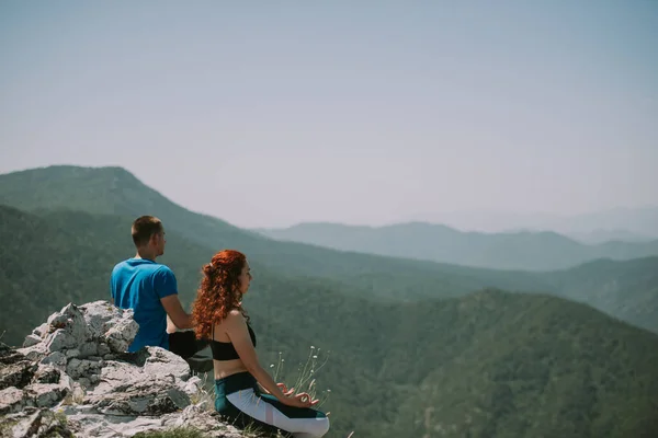 Partnerzy Jogi Relaksujący Się Siedząc Szczycie Góry — Zdjęcie stockowe