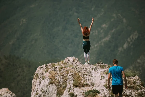 在女孩举手表决的山顶上 有对瑜伽情侣 — 图库照片