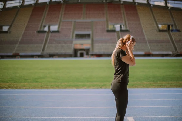 Uma Rapariga Desportiva Está Pôr Auscultadores Cabeça Ela Vai Correr — Fotografia de Stock