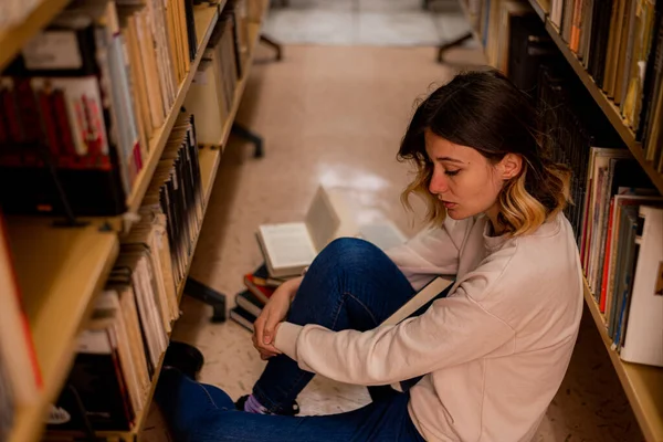 Zmęczona Studentka Siedzi Bibliotece Między Regałami — Zdjęcie stockowe