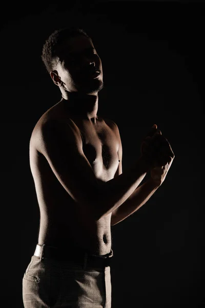 Young black male is posing topless on silhouette