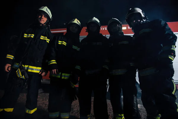 消防士のグループは 長い水のホースで火を出す — ストック写真