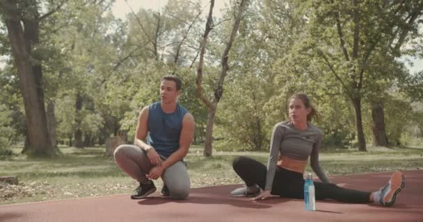 Pasangan Muda Peregangan Sebelum Latihan Taman Adegan Matahari Terbenam Musim — Stok Video
