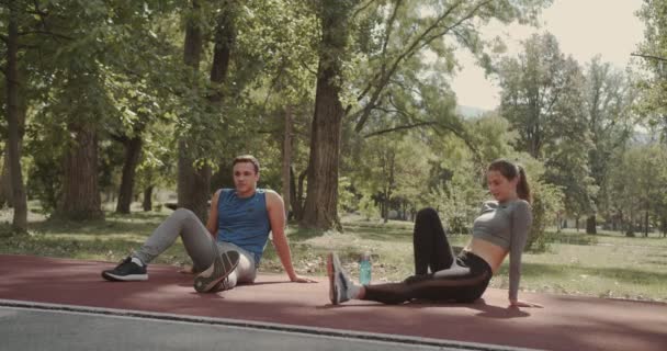 Fiatal Pár Pihenő Edzés Előtt Parkban Futó Tartán Pályán Ivóvíz — Stock videók