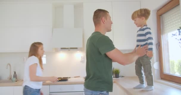 Син Стрибає Руки Батьків Кухонного Столу — стокове відео