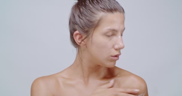 漂亮的女人在她的脸和肩膀上涂上白霜并按摩它们 洁肤洁肤 面容清澈 护肤治疗或化妆品广告概念 — 图库视频影像