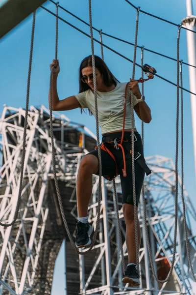 在探险公园里操作最坚硬绳索的女人毫无困难 — 图库照片