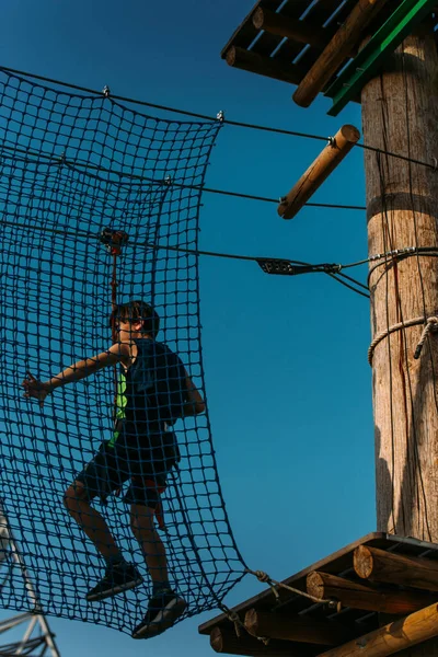 小男孩在冒险公园的坚固的网桥上挣扎着 — 图库照片