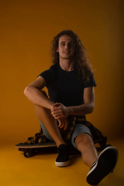 Fit Und Gut Aussehender Junge Sitzt Auf Seinem Skateboard Mit — Stockfoto
