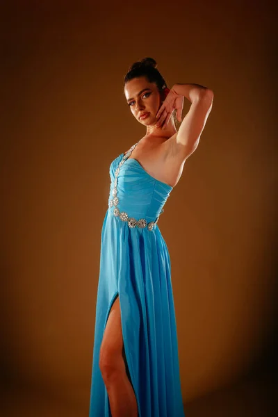 Oszałamiająca Dziewczyna Balu Pozująca Niebieskiej Sukience Dotyka Szyi Lewą Ręką — Zdjęcie stockowe