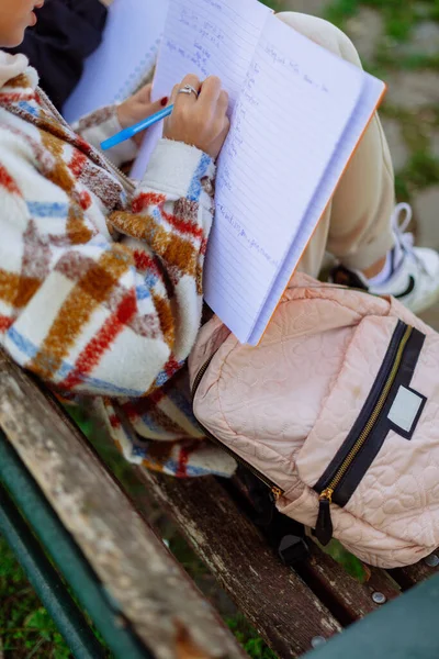 学校の庭で学校の後に彼女の宿題を書くスタイリッシュなティーン — ストック写真