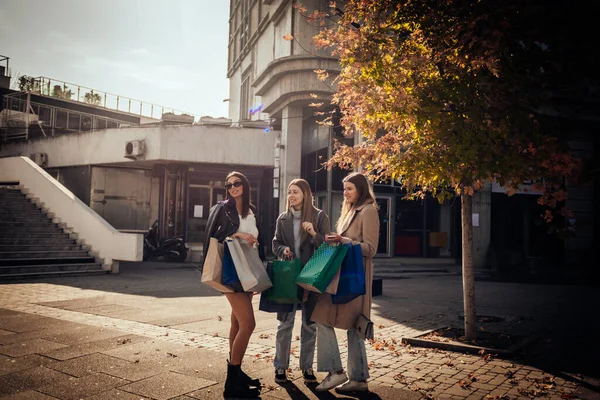 Три Девушки Стоят Сумками Смотрят Витрину Магазина — стоковое фото