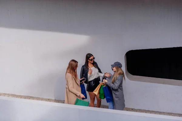 3人の幸せな女の子がモールで買い物に行こうとしている 彼らは話していて楽しい会話をしている — ストック写真