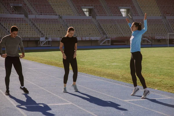 Arkadaşları Koşuya Hazırlanırken Mavi Bluzlu Bir Kız Zıplıyor — Stok fotoğraf