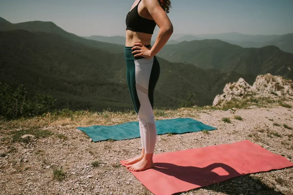 瑜伽女孩站在山顶的瑜伽垫上 — 图库照片