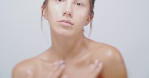 Vacker Kvinna Vidrör Varsamt Ansiktet Och Axlarna Isolerade Vitt Närbild — Stockvideo