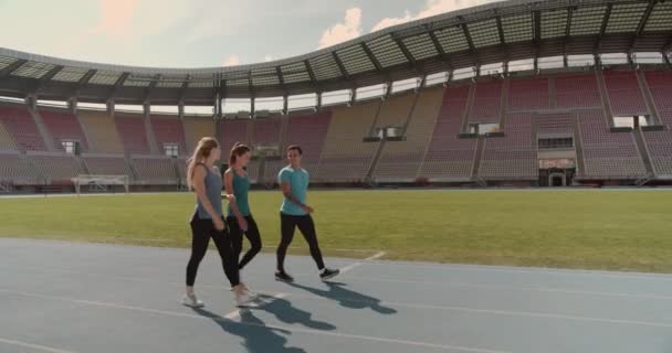 Three People Walking Race Track Stadium — Stock Video