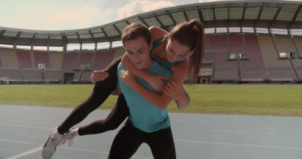 Junge Übt Gewichtheben Mit Seiner Freundin Und Hebt Sie Stadion — Stockvideo