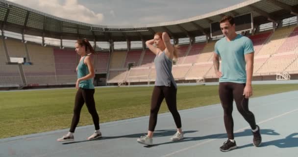 Νέοι Αθλητές Περπατούν Και Μετά Κάνουν Τζόκινγκ Στο Στάδιο Αθλητική — Αρχείο Βίντεο