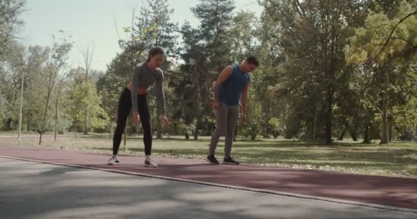 Genç Çift Sonbaharda Parktaki Yarış Pistinde Koşmaya Hazırlanıyor — Stok video