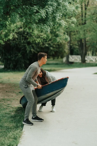 Piękna Para Próbuje Podnieść Kajak Podczas Spaceru Parku — Zdjęcie stockowe