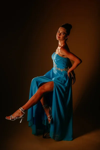Dziewczyna Niebieskiej Sukience Wysokich Obcasach Siedzi Krześle Prawą Nogą Górze — Zdjęcie stockowe