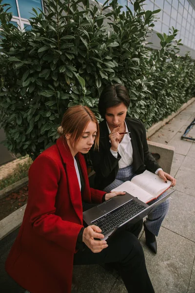 Duas Mulheres Negócios Olhando Para Laptop Enquanto Sentado Banco — Fotografia de Stock