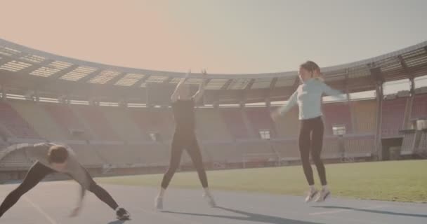 三个人在体育馆里进行伸展和跳跃 准备跑步 — 图库视频影像