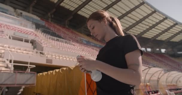 Γυναίκα Βάζοντας Ακουστικά Πριν Από Την Πρακτική Μέσα Στο Γήπεδο — Αρχείο Βίντεο