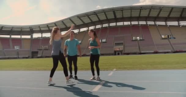 Три Молодых Человека Празднуют Спортивную Победу Стадионе — стоковое видео