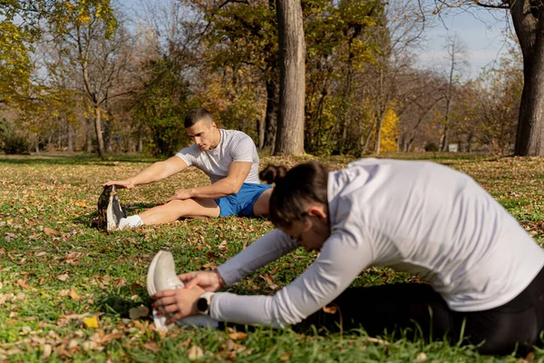 Two Attractive Amazing Fit Friends Stretching Grass While Being Focused — Foto de Stock