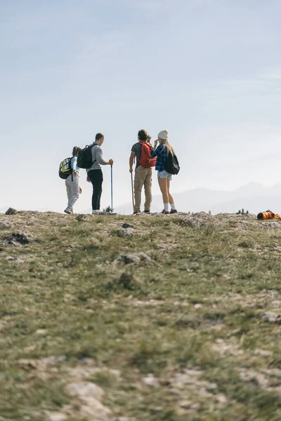 Four hikers standing at the top of the mountain