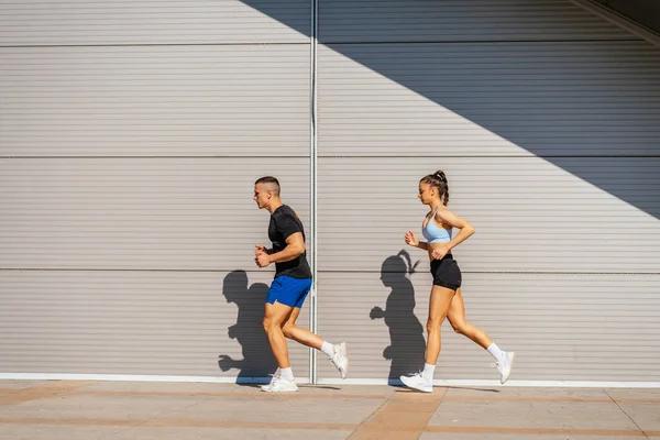 Sexy Sports Couple Running Row Together Next Garage —  Fotos de Stock